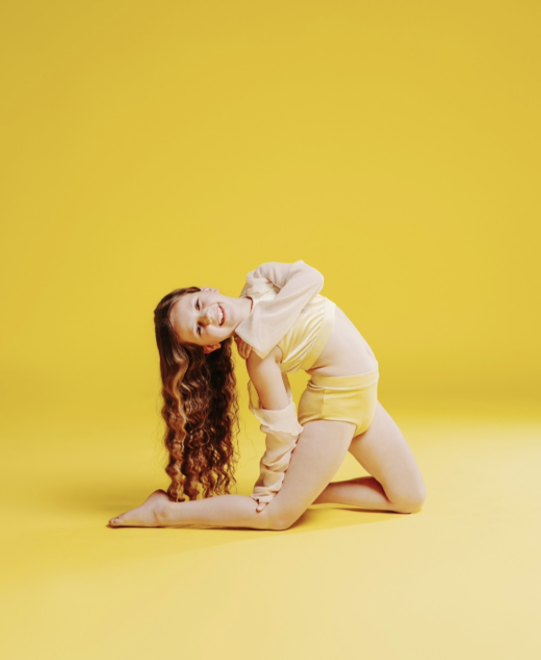 Olivia in a backbend pose on a bright yellow studio backdrop