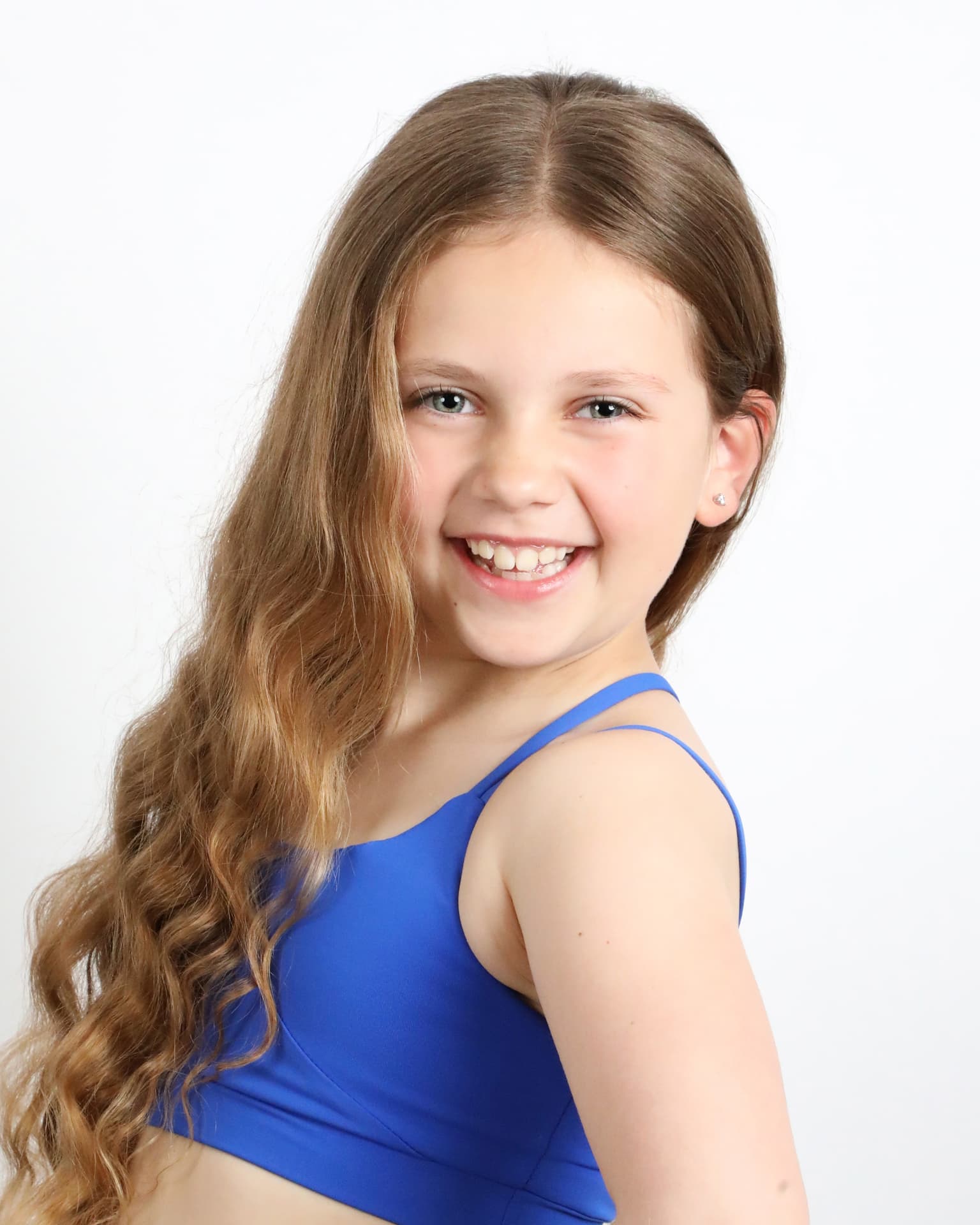 Smiling headshot of Olivia in a royal blue top against a white studio backdrop